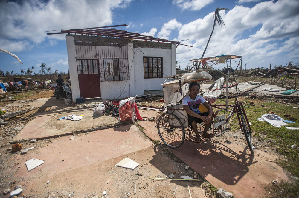 131115-N-BD107-722 GUIUAN, Eastern Samar Province, Republic of the Philippines (Nov. 15, 2013) A Guiuan resident sits in a ricksha outside of his ruined home in the aftermath of Super Typhoon Haiyan. The George Washington Carrier Strike Group support