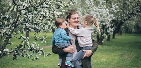 Vater mit zwei Kindern im Arm
