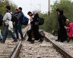 Flüchtlinge überqueren am 19. Oktober 2015 Bahngleise auf dem Weg von dem Transitlager Idomeni durch Mazedonien nach Serbien. Ziel der Flüchtlinge ist der Bahnhof in Belgrad, von dem aus sie mit dem Zug weiterreisen.